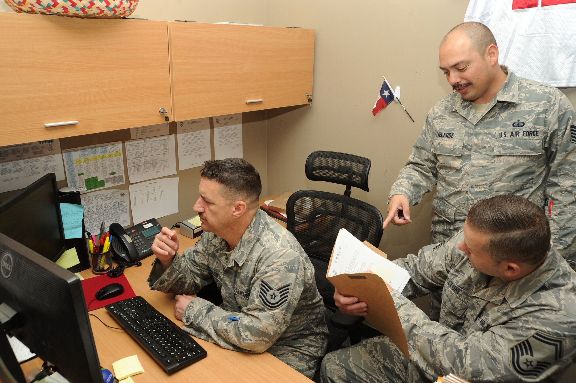 Tech Sgt. Christopher Gonzales, left, and Tech. Sgt. David Velarde, middle, 386th Expeditionary Contracting Squadron contracting officers, team up with Senior Master Sgt. Michael McClure, 386th Air Expeditionary Wing finance office superintendent, to obligate funds for a contract Sep. 29, 2016 at an undisclosed location in Southwest Asia. The finance office and the 386 ECONS worked together for about 180 hours during the close of fiscal year 2016. (U.S. Air Force photo/Senior Airman Zachary Kee)
