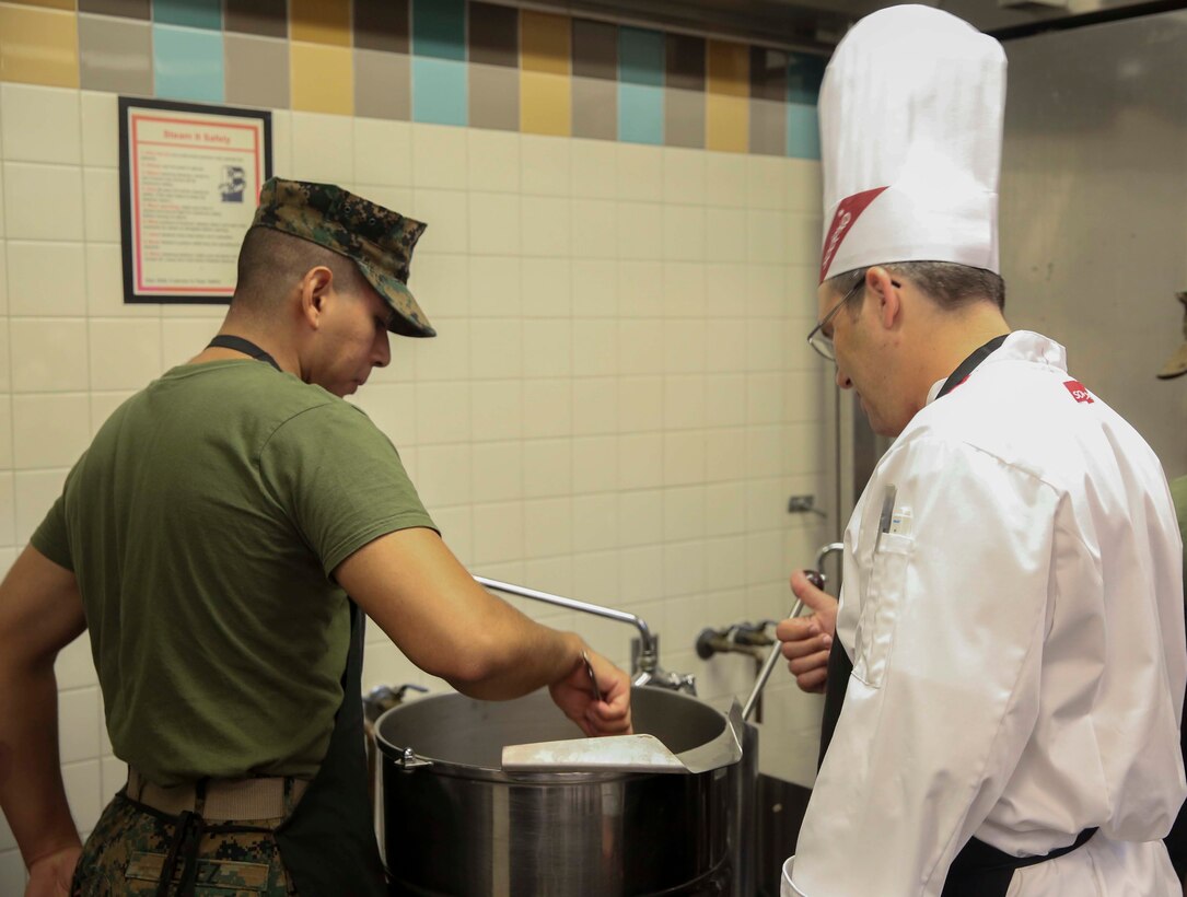 Pfc. Andrew Perez, a food service specialist with Combat Logistics Battalion 26, works with Steven Dziedzic, chef instructor with Sodexo, to make beef bourguignon at Mess Hall 128 on Marine Corps Base Camp Lejeune, Sept. 22. The Sodexo Company Quality of Life Services teaches methods to Marine food service specialist to improve the basic services involving in stir fry cooking, steaming, boiling, sautéing food, roasting, braising, stewing and knife skills across the installation.