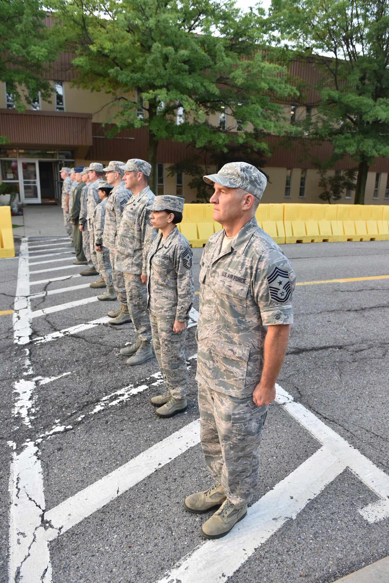 911th Airlift Wing Command Chief Master Sgt. Brian Zator, Air Force Reserve Command Chief Master Sgt. Erica Kelly, 22nd Air Force Command Chief Master Sgt. Clint Ronan, and other members of the 911th AW stand in formation prior to reveille at the Pittsburgh International Airport Air Reserve Station, September 10, 2016. Zator relinquished his position as command chief and retired after just over 33 years of service. (U.S. Air Force photo by Staff Sgt. Marjorie A. Bowlden)