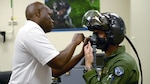 A Rockwell Collins customer support specialist fits and issues an F-35 Lightning II Generation III Helmet Mounted Display System at Luke Air Force Base, Arizona. The Defense Contract Management Agency and Rockwell Collins signed a Memorandum of Agreement Sept. 21, establishing an improved process for procurement of commercial items for military application. 
