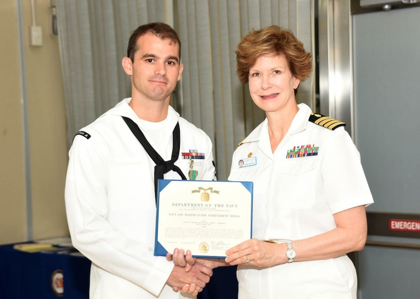 U.S. Naval Hospital Yokosuka’s commanding officer, Navy Capt. Rosemary C. Malone, right, presents the Navy and Marine Corps Achievement Medal to Navy Petty Officer 2nd Class Joshua Blanchard, a hospital corpsman, during a ceremony at the Japan-based hospital, Sept. 13, 2016. Blanchard was honored for saving the life of a drowning mother on Aug. 16, 2016, during his temporary duty at the Surface Warfare Medical Institute in San Diego. Navy photo by Gregory Mitchell