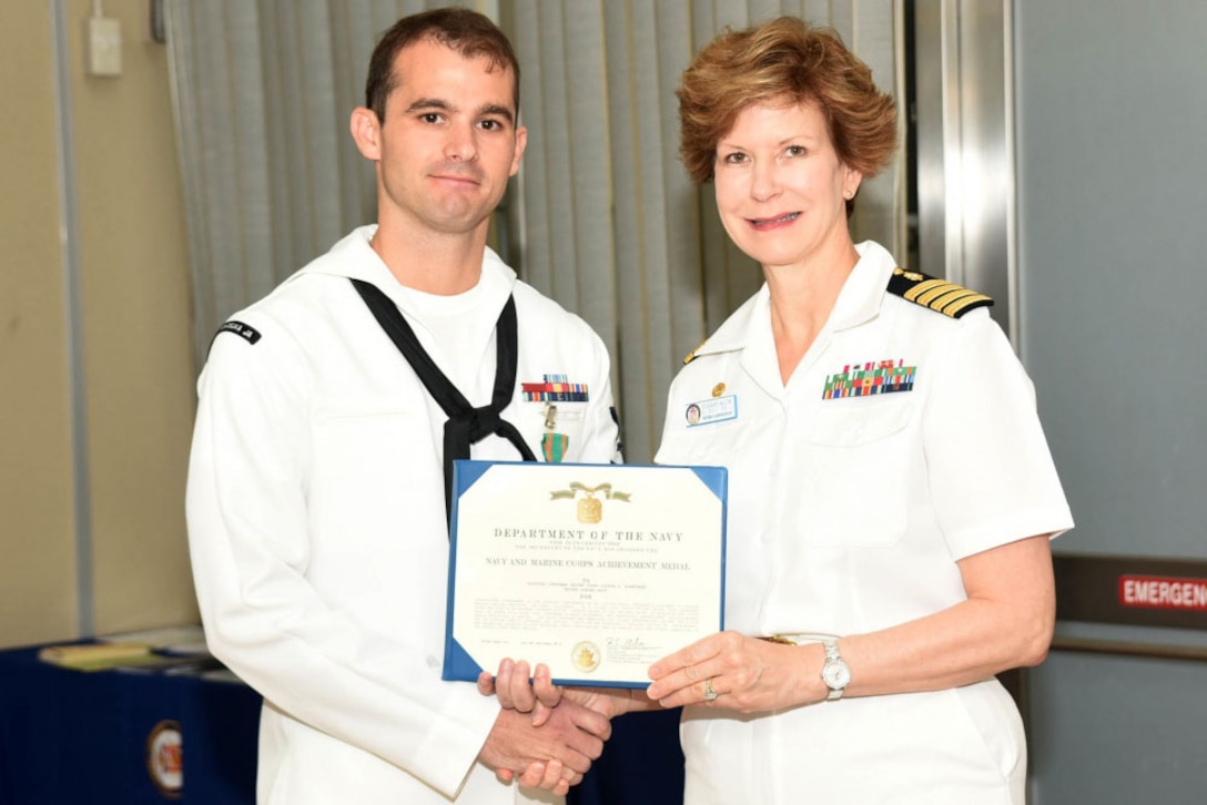 U.S. Naval Hospital Yokosuka’s commanding officer, Navy Capt. Rosemary C. Malone, right, presents the Navy and Marine Corps Achievement Medal to Navy Petty Officer 2nd Class Joshua Blanchard, a hospital corpsman, during a ceremony, Sept. 13, 2016. Blanchard was honored for saving the life of a drowning mother during his temporary duty at the Surface Warfare Medical Institute in San Diego. Navy photo by Gregory Mitchell