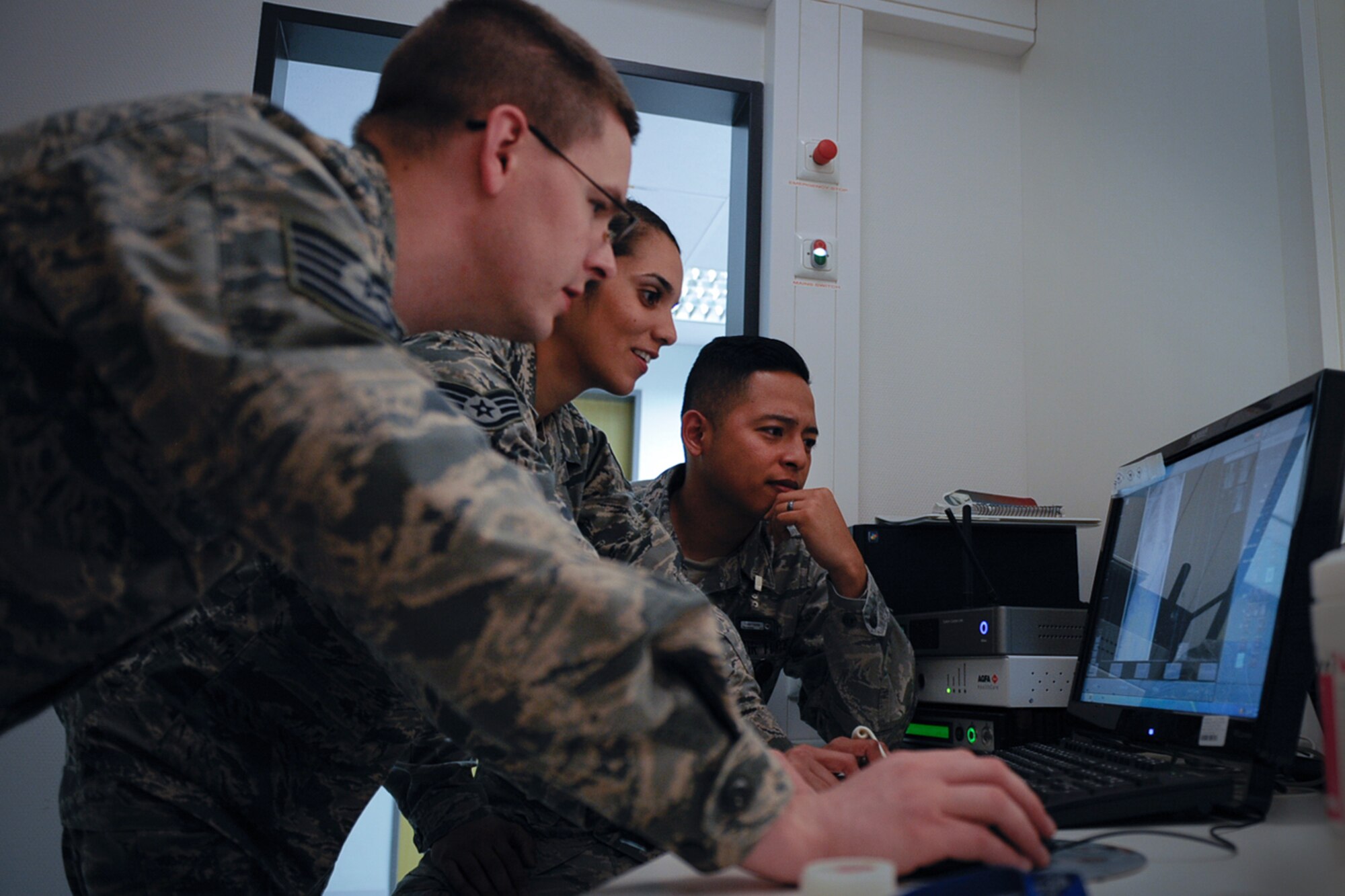 Tech Sgt. Timothy Jenkins (left), Staff Sgt. Silvia Ruiz (middle), and Staff Sgt. Erick Alvarez, 86th Medical Support Squadron radiology diagnostic imaging technicians, examine an x-ray at Ramstein Air Base Germany, Sept. 29, 2016. After an x-ray is taken, it’s examined before being sent to a radiologist at Landstuhl Regional Medical Center.  (U.S. Air Force photo/ Airman 1st Class Savannah L. Waters)