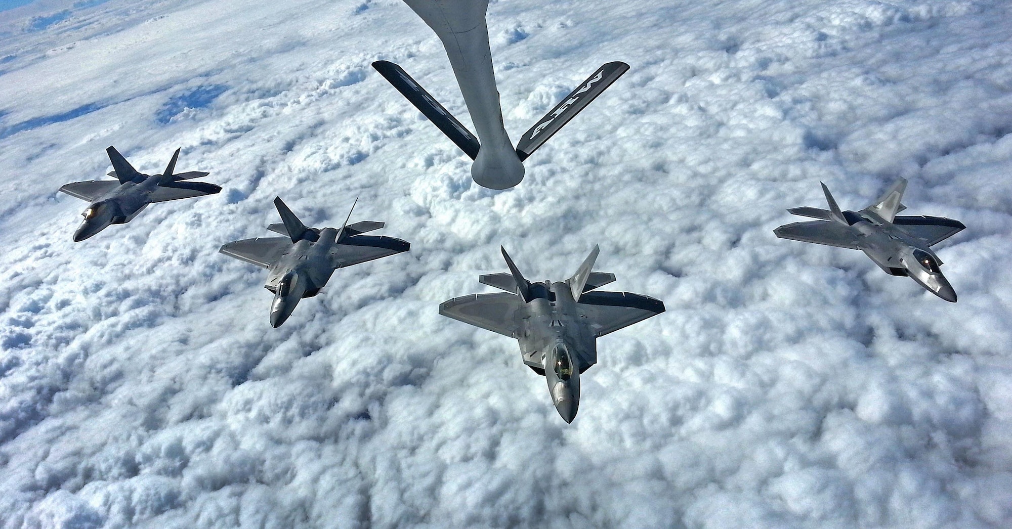 Four F-22 Raptors from the 27th Fighter Squadron out of Joint Base Langley-Eustis, Va., fly in formation below a 434th Air Refueling Wing KC-135R Stratotanker from Grissom Air Reserve Base, Ind., prior to a flyover in Tipton, Ind., Sept. 29, 2016.  The flyover was part of a memorial ceremony for Army Air Corps Lt. Robert McIntosh, who passed away after his aircraft crashed during World War II. (U.S. Air Force Photo/Col. Hiram Gates)