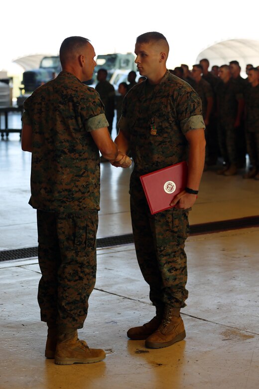 Brig. Gen. Matthew Glavy awards Lance Cpl. Jedidiah Hunt with The Navy and Marine Corps Achievement Medal in front of Marines with Marine Attack Squadron 231 during an award ceremony aboard Marine Corps Air Station Cherry Point, N.C., Sept. 28, 2016. The Marines took a brief pause from their pre-deployment preparations to award Hunt for outstanding performance in his duties during an exercise in May 2016. The squadron is slated to continue training for their upcoming deployment in the fall. Glavy is the commanding general for 2nd Marine Aircraft Wing and Hunt is an aircraft mechanic with VMA-231. (U.S. Marine Corps photo by Lance Cpl. Mackenzie Gibson/Released)