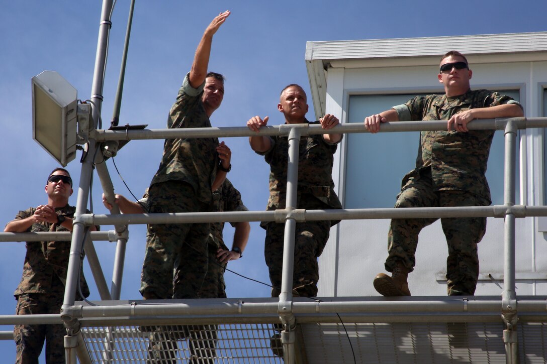 Brig. Gen. Matthew Glavy stands on top of a control tower with Lt. Col. Matthew Simmons (left), Col. Paul Baker (center left) and Maj. Adam McArthur (right) from the outlying field working group during a visit aboard Marine Corps Auxiliary Landing Field Bogue, N.C., Sept. 28, 2016. Glavy visited the airfield to thank Marines for their hard work, to better understand the challenges they overcome on a daily basis and set eyes on supporting facilities to ensure they are maintained to high standards. “Bogue represents the 2nd Marine Aircraft Wing’s ability to conduct expeditionary operations,” said Glavy. “They provide aviation ground support, air traffic control and operational support to the aircraft that rely on them. It is a unique place where 2nd MAW can get critical expeditionary training that we cannot receive anywhere else.” Glavy is the commanding general for 2nd MAW, Simmons is the assistant chief of staff in the 2nd MAW G6, Baker is the officer in charge of the aviation ground support department and McArthur is the aviation ranges project lead in 2nd MAW G3. (U.S. Marine Corps photo by Lance Cpl. Mackenzie Gibson/Released)