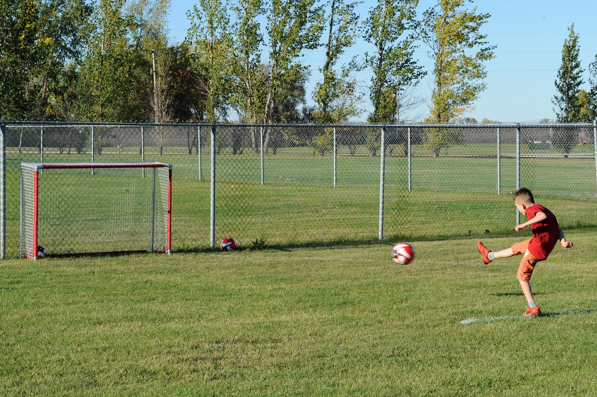 A military child kicks a soccer ball during the Ninja Warrior obstacle course at Minot Air Force Base, N.D., Sept. 26, 2016. The event was held for all military members to enjoy, both adults and children. (U.S. Air Force photo/Senior Airman Kristoffer Kaubisch)