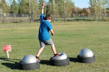 A military child runs across “ninja balls” during the Ninja Warrior obstacle course at Minot Air Force Base, N.D., Sept. 26, 2016. The event had over 10 obstacles for the children and adults to go through. (U.S. Air Force photo/Senior Airman Kristoffer Kaubisch)