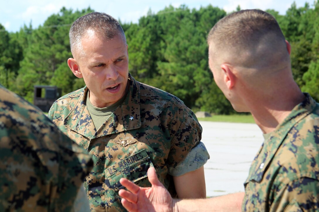Brig. Gen. Matthew Glavy listens to Lt. Col. Steven Schultze during a visit aboard Marine Corps Auxiliary Landing Field Bogue, N.C., Sept. 28, 2016. Glavy visited the airfield to thank Marines for their hard work, to better understand the challenges they overcome on a daily basis and set eyes on supporting facilities to ensure they are maintained to high standards. “Bogue represents the 2nd Marine Aircraft Wing’s ability to conduct expeditionary operations,” said Glavy. “They provide aviation ground support, air traffic control, and operations support to the aircraft that rely on them. It is a unique place where 2nd MAW can get critical expeditionary training that we cannot receive anywhere else.” Glavy is the commanding general for 2nd MAW, and Schultze is the commanding officer for Marine Wing Support Squadron 271. (U.S. Marine Corps photo by Lance Cpl. Mackenzie Gibson/Released)