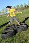 A military child hops through tires during the Ninja Warrior obstacle course at Minot Air Force Base, N.D., Sept. 26, 2016. The event was held for all military members to enjoy, both adults and children. (U.S. Air Force photos/Senior Airman Kristoffer Kaubisch)