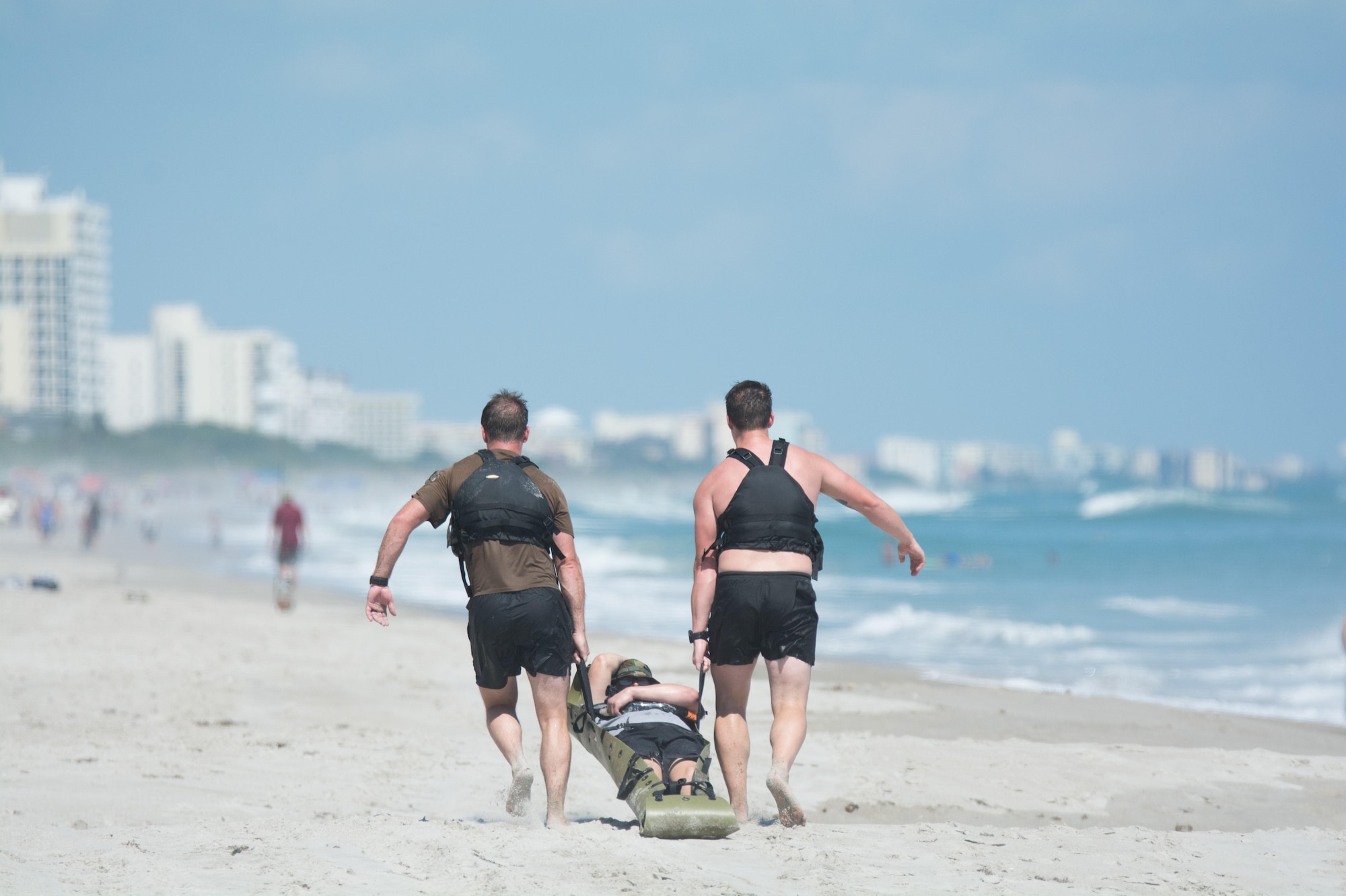 Two pararescumen (PJs) drag a patient down the beach during the 2016 Pararescue Rodeo hosted by the 920th Rescue Wing, Patrick Air Force Base, Florida, September 23, 2016. The rodeo, also known as a skills competition, was a week-long event which tested PJs on skill sets such as precision-parachute jumping, rifle and pistol accuracy shooting, open-ocean surface swimming, high-angle and confined space rescues, water rescues and overall physical endurance. (U.S. Air Force photo/Staff Sgt. Dana White)