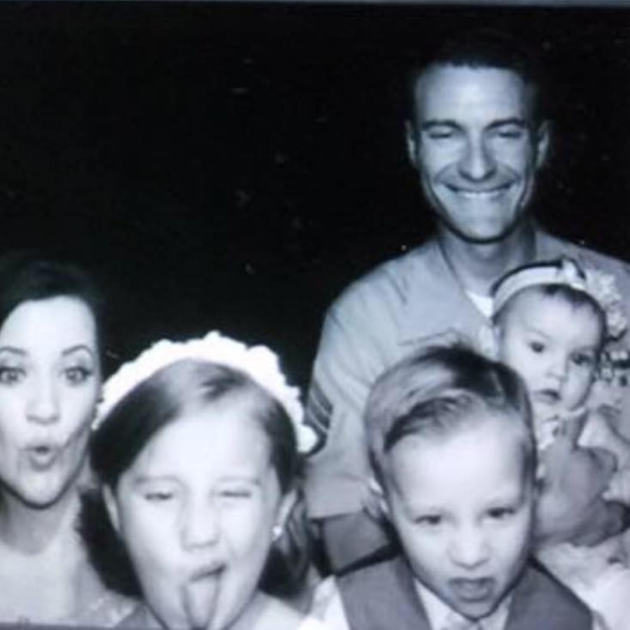 Staff Sergeant Nicholas Beberniss with his family having fun in a photo booth during a family event. 
