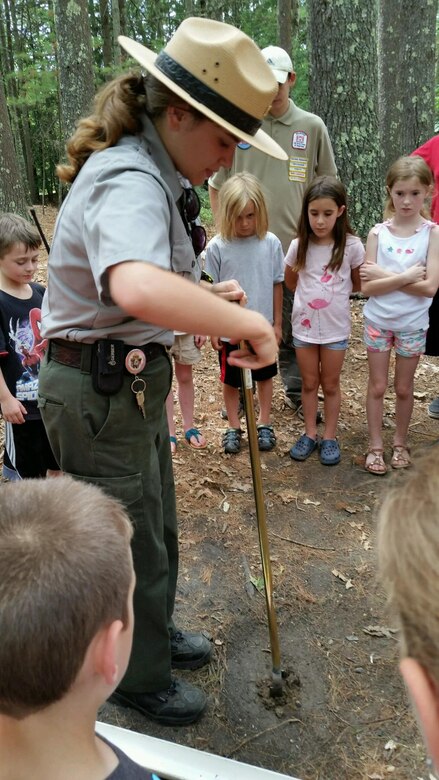 Park Ranger Sally Carullo operates an auger to dig through soil layers during the  Beginning Bridges Five Senses and Solar Power Day held on July 20, 2016 at West Hill Dam in Massachusetts.