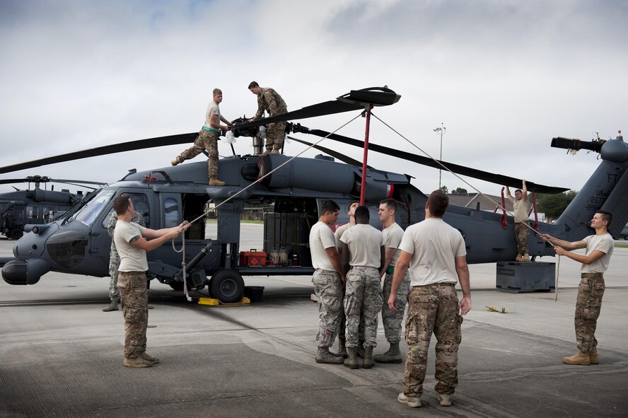 U.S. Air Force Airmen assigned to the 41st Helicopter Maintenance Unit work together to fold a blade attached to an HH-60G Pave Hawk during rapid rescue preparation before the helicopter deployed, Sept. 13, 2006, at Moody Air Force Base, Ga. After a helicopter is fully prepared, Airmen can load it onto a C-5 Galaxy or a C-17 Globemaster III. (U.S. Air Force photo by Airman 1st Class Daniel Snider)