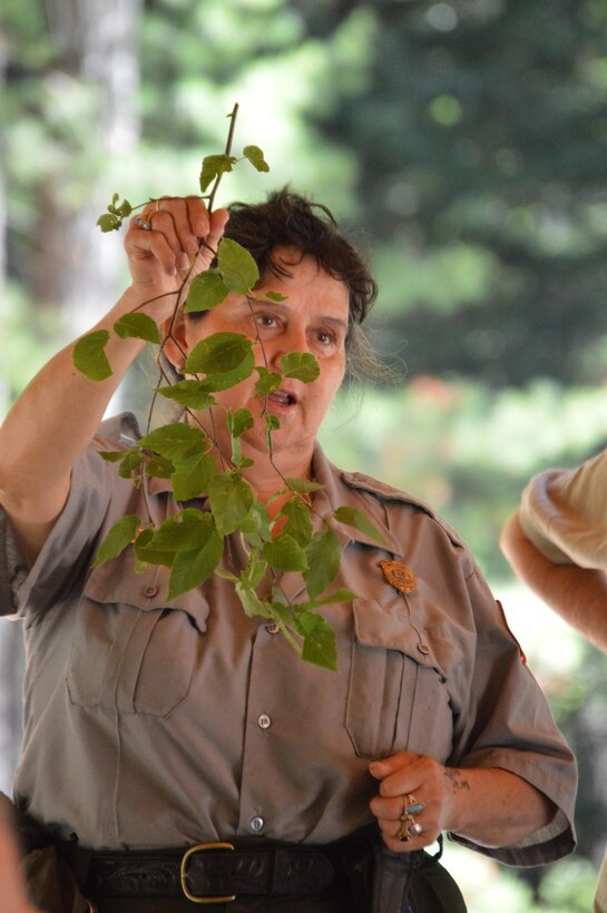 Park Ranger Viola Bramel holds up a tree branch and identifies it to her audience during the  Beginning Bridges Five Senses and Solar Power Day at West Hill Dam in Massachusetts on July 20, 2016.  