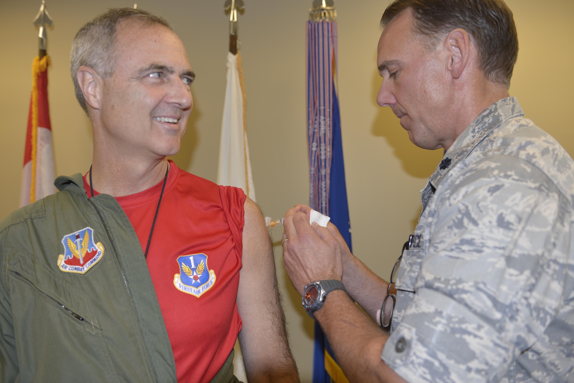 Lt. Gen. Scott Williams, Commander, 1st  Air Force (Air Forces Northern) and Commander, Continental U.S. North American Aerospace Defense Command Region, asks Lt. Col. Greg Martin, 1st Air Force surgeon's office, "Did you already give me the shot?" after the painless flu shot. Williams was first in line for the flu shot season Sept. 30.  The 1st AF surgeon's office is aiming to administer flu shots to approximately 600 command personnel. Martin has overseen the flu shot program at 1st AF for the past four years.  (U.S. Air Force photo by Tom Saunders)