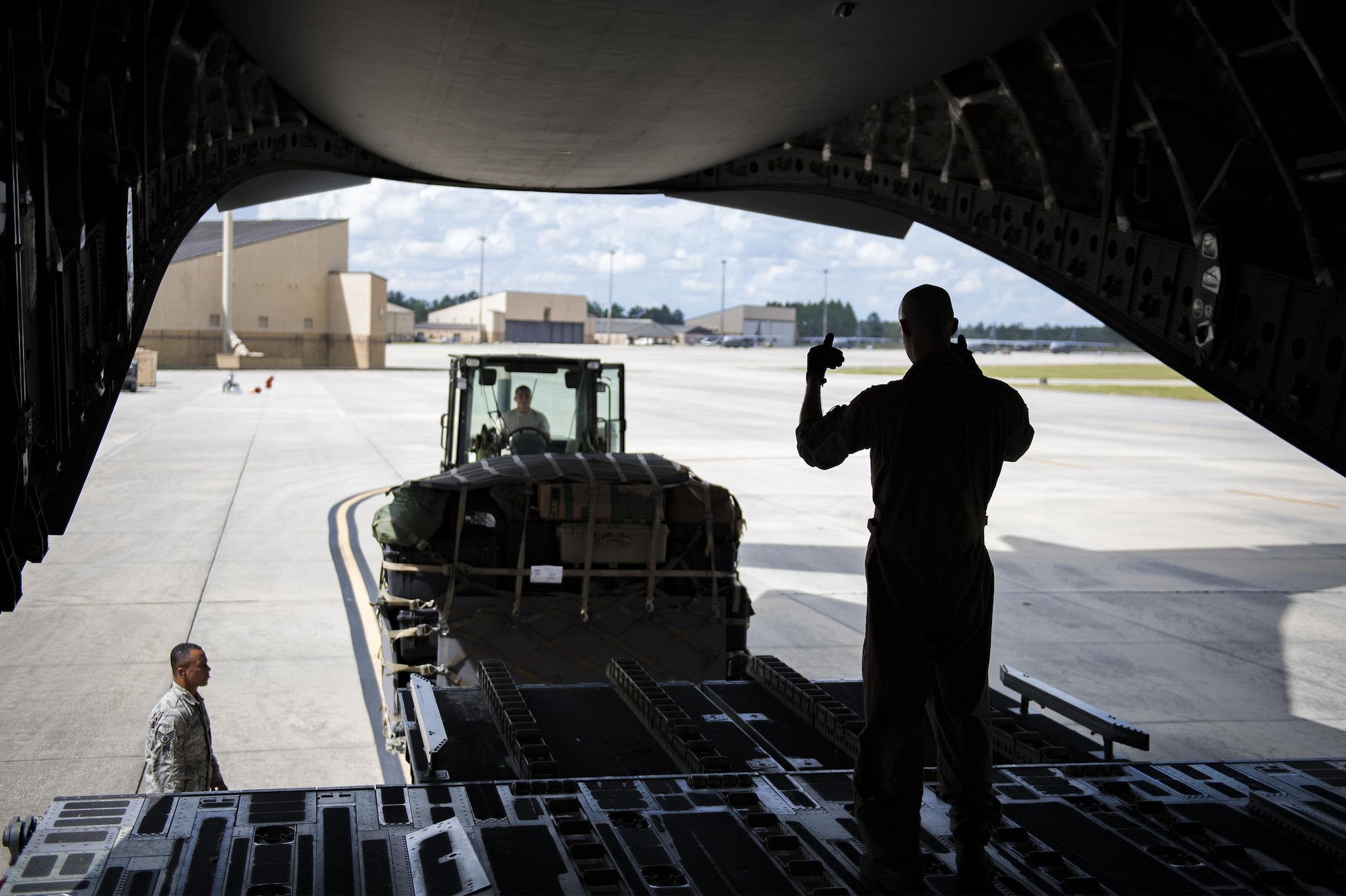 U.S. Air Force Staff Sgt. Ryan Nichols, 7th Airlift Squadron loadmaster, assists Staff Sgt. Brennon Scott, 23d Logistics Readiness Squadron air terminal operations supervisor, in loading baggage and weapons onto a C-17 Globemaster III, Sept. 26, 2016, at Moody Air Force Base, Ga. As the loadmaster, Nichols supervised everything entering the aircraft, prepared seating for Airmen and ensured everything on board was secure for flight. (U.S. Air Force photo by Airman 1st Class Daniel Snider)