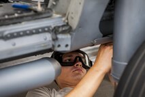 U.S. Air Force Airman 1st Class Igor Ganchenko, 41st Helicopter Maintenance Unit crew chief, removes panels form the underside of an HH-60G Pave Hawk during rapid recue preparation before the helicopter deployed, Sept. 13, 2016, at Moody Air Force base, Ga. Many adjustments removing panels and adding hooks prepared the helicopter for a deployment to Southeast Europe. (U.S. Air Force photo by Airman 1st Class Daniel Snider)