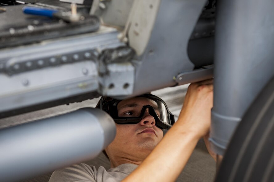 U.S. Air Force Airman 1st Class Igor Ganchenko, 41st Helicopter Maintenance Unit crew chief, removes panels form the underside of an HH-60G Pave Hawk during rapid recue preparation before the helicopter deployed, Sept. 13, 2016, at Moody Air Force base, Ga. Many adjustments removing panels and adding hooks prepared the helicopter for a deployment to Southeast Europe. (U.S. Air Force photo by Airman 1st Class Daniel Snider)