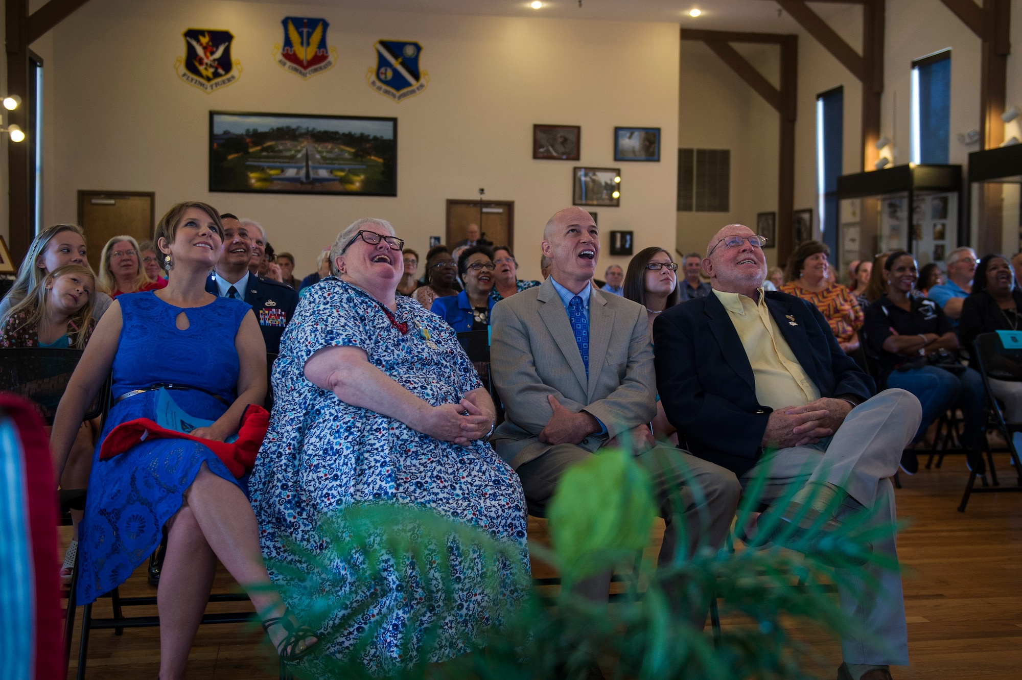 Ann Lukens, 23d Force Support Squadron school liaison officer, and her family shares a laugh during a tribute video at her retirement ceremony, Sept. 30, 2016, at Moody Air Force Base, Ga. Lukens says she will continue to enjoy exploring historical locations as well as spending time with her husband, son, daughter-in-law and four grandchildren. (U.S. Air Force photo by Airman 1st Class Greg Nash)