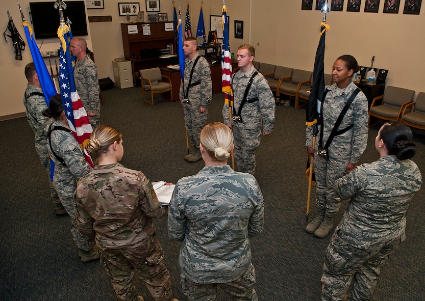 Airmen with the Minot Air Force Base Honor Guard go over the different steps in presenting the colors at Minot Air Force Base, N.D., Sept. 27, 2016. While maneuvering with the flags in areas with low ceilings, Airmen carry the flags in a position known as “port arms” in order to prevent the flag from hitting the ceiling. (U.S. Air Force photo/Airman 1st Class Jonathan McElderry) 