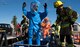 Firefighters from the 92nd Civil Engineer Squadron assist in decontaminating a hazardous materials team’s protective suits after responding to a chemical leak during an Emergency Management Exercise Sept. 29, 2016, at Fairchild Air Force Base, Wash. Exercises allow Airmen to practice vital skills in various formats to keep emergency response abilities sharp in the event of an actual crisis. (U.S. Air Force photo/Airman 1st Class Ryan Lackey)