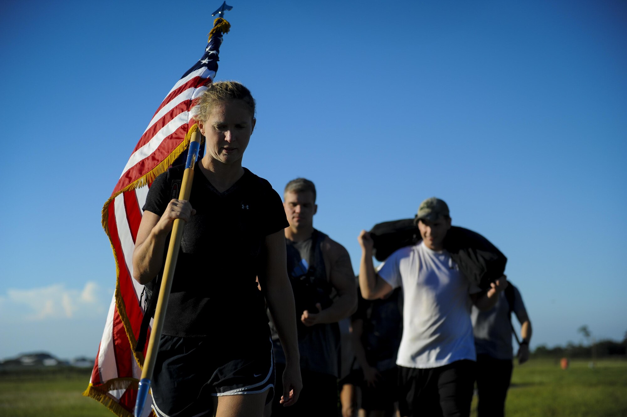 Angela Gilzene, a fitness specialist with the 1st Special Operations Force Support Squadron, carries the American Flag during a ruck march at Hurlburt Field, Fla., Sept. 29, 2016.. A ruck march is an activity where individuals carry a large back-pack, called a ruck that could weigh over 100 pounds. (U.S. Air Force photo by Airman Dennis Spain)
