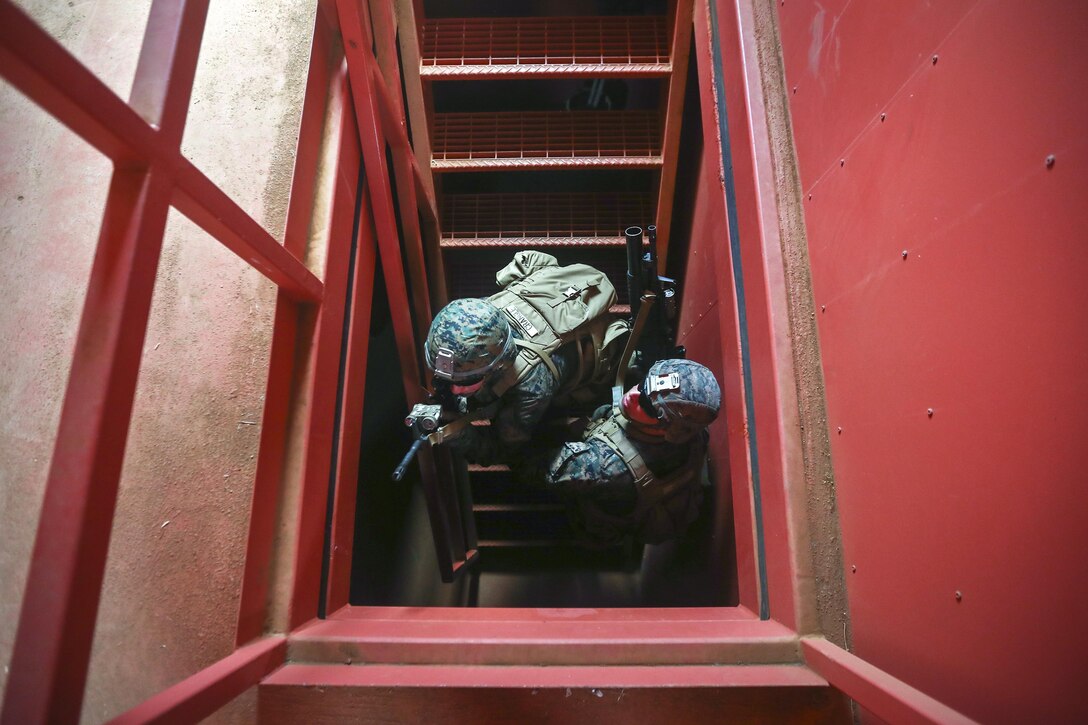 Marines climb a staircase while looking for threats during Island Viper at Marine Corps Base Hawaii, Sept. 28, 2016. During the annual predeployment training event, Marines practice clearing buildings, patrolling through simulated villages, completing obstacles and traversing through an improvised explosive device course. Marine Corps Photo by Cpl. Aaron S. Patterson