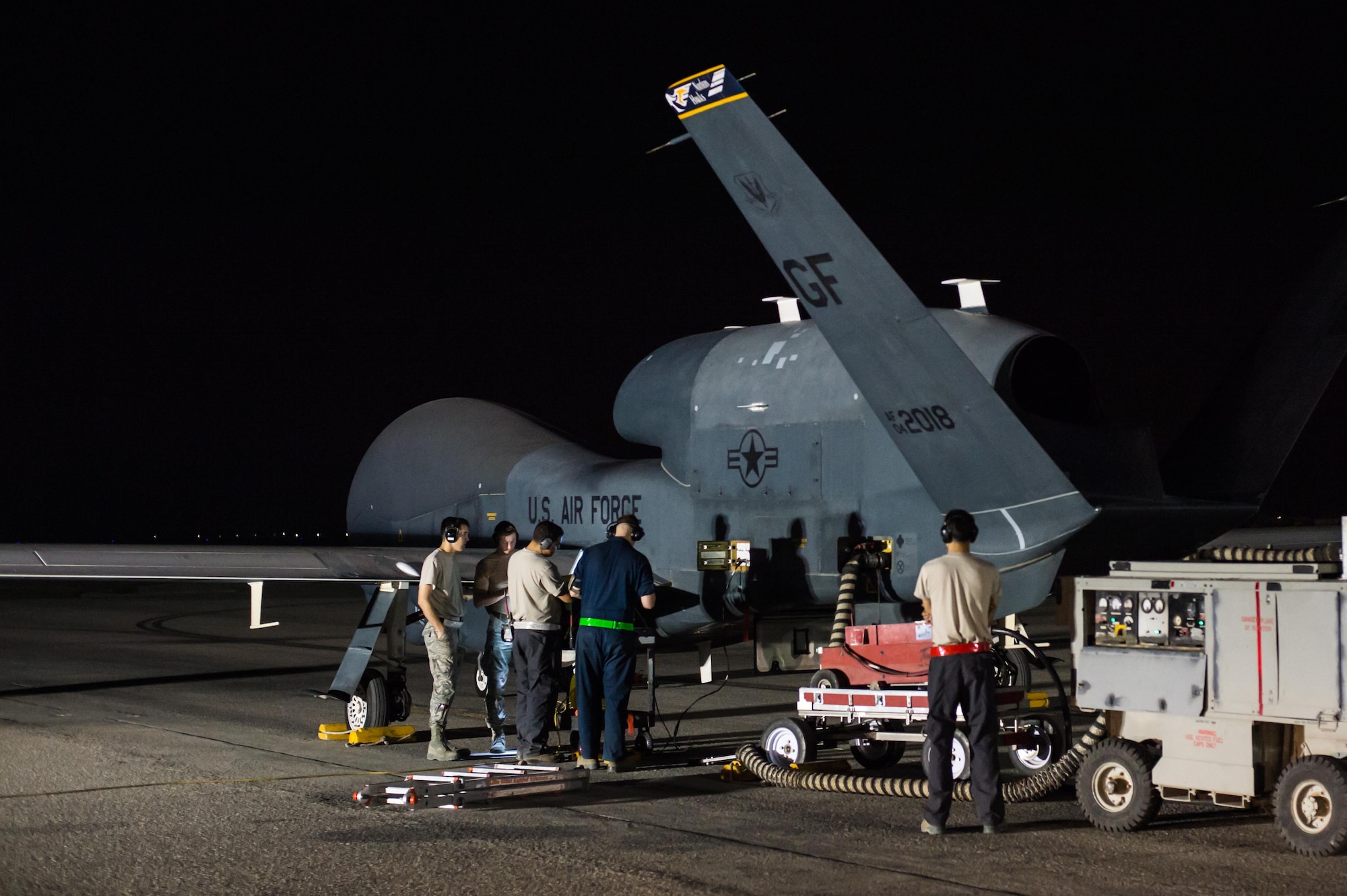 Members of the 380th Expeditionary Maintenance Squadron complete pre-flight checks on an EQ-4 Global Hawk equipped with a battlefield airborne communications node at an undisclosed location in Southwest Asia, March 31, 2017. This launch marked 1000 consecutive sorties without a maintenance cancel while supporting Combined Joint Task Force-Operation Inherent Resolve. These remotely piloted aircraft have provided a critical communication bridge between multi-national Coalition assets working to defeat ISIS in the area of responsibility. (U.S. Air Force/Senior Airman Tyler Woodward)