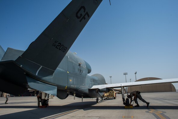 Members of the 380th Expeditionary Maintenance Squadron complete post-flight checks on an EQ-4 Global Hawk equipped with a battlefield airborne communications node at an undisclosed location in Southwest Asia, April 1, 2017. The completion of this mission marked 1000 consecutive sorties without a maintenance cancel while supporting Combined Joint Task Force-Operation Inherent Resolve. These remotely piloted aircraft have provided a critical communication bridge between multi-national Coalition assets working to defeat ISIS in the area of responsibility. (U.S. Air Force/Senior Airman Tyler Woodward)