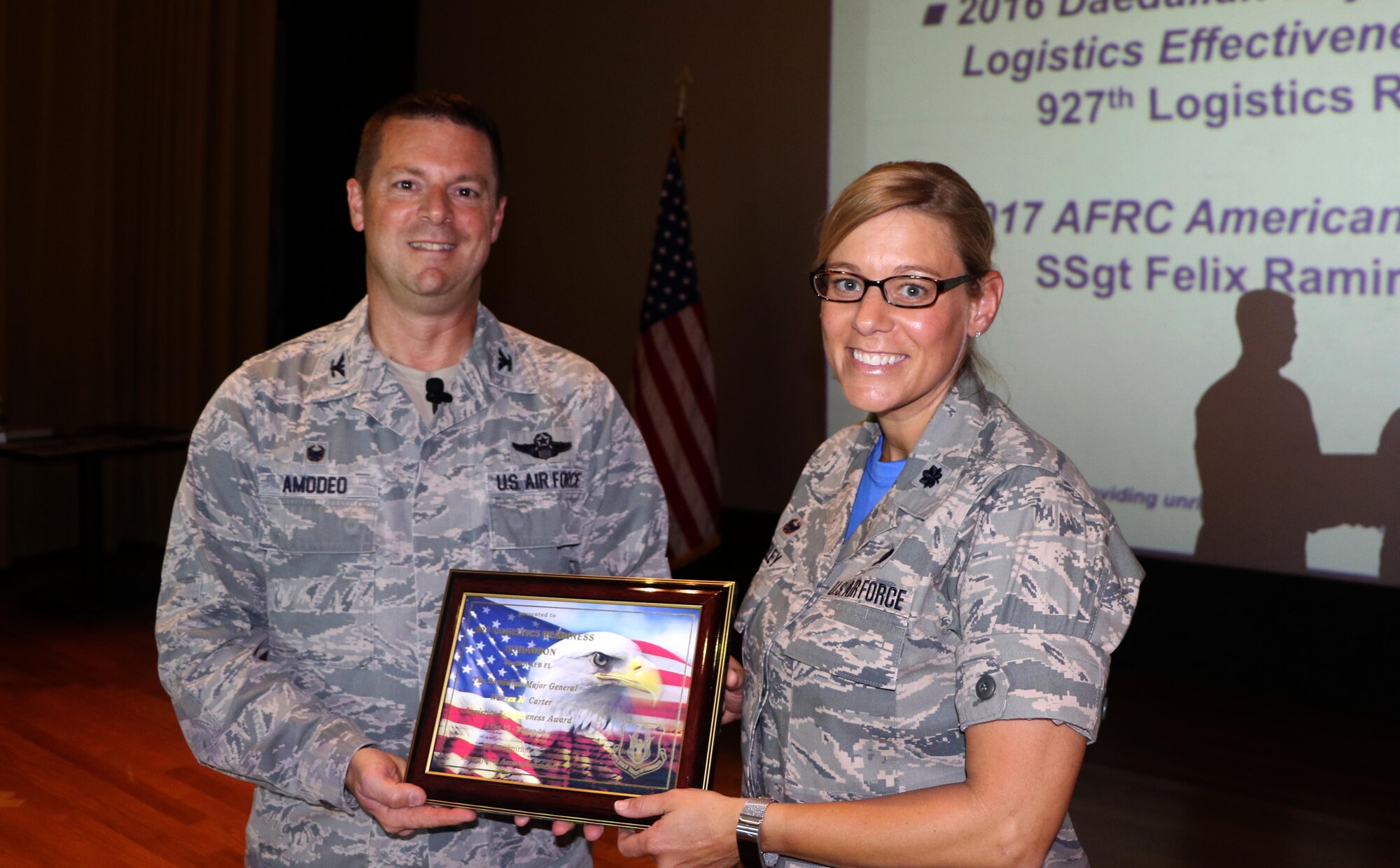 Col. Frank Amodeo 927th Air Refueling Wing commander presents Lt. Col. Meredith Seeley, 927th Logistics Readiness Squadron commander, with an award for her squadron at Commander’s call held at MacDill Air Force Base, FL during Saturday of the April Unit Training Assembly. Amodeo began the event by presenting wing awards to members of the 927 ARW. (U.S. Air Force photo by Staff Sgt. Xavier Lockley)