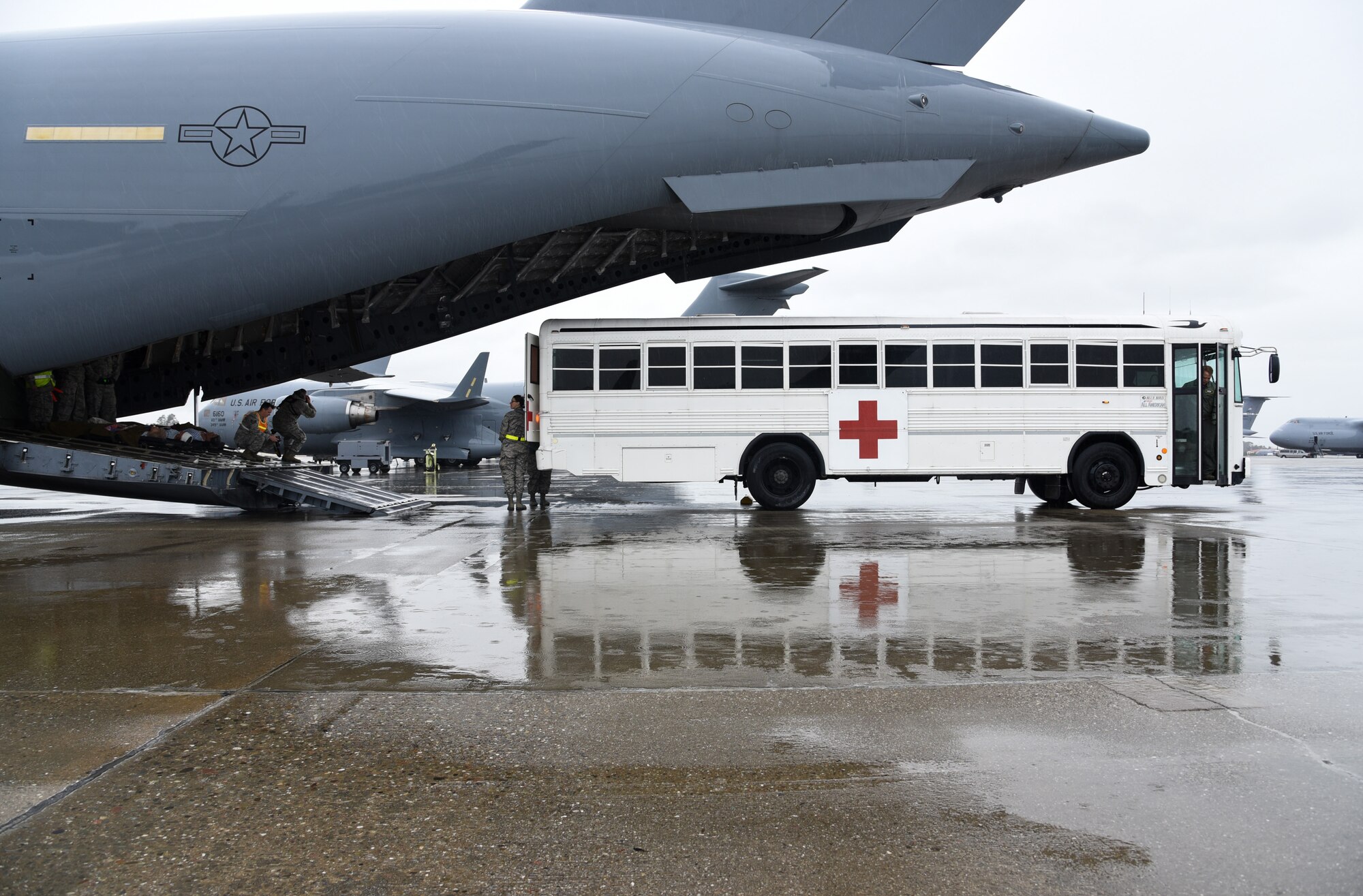 An ambulatory bus reverses to a C-17 Globemaster III to transport patients at Travis Air Force Base, Calif., March 24, 2017. This scenario was part of Patriot Delta, an aeromedical evacuation training exercise. (U.S. Air Force photo by Senior Airman Sam Salopek)