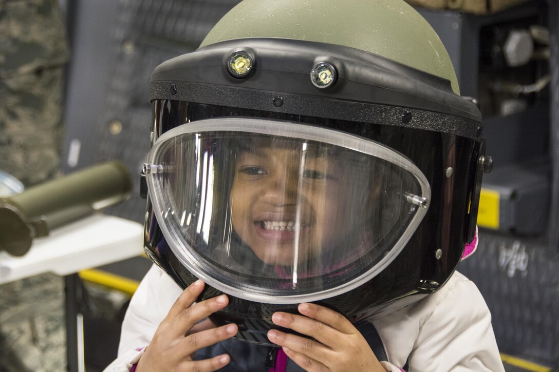 Jordin Mingo tries on a bomb suit helmet on Dover Air Force Base, Del., April 1, 2017. Family members attended a Month of the Military Child event involving tours of a C-5M Super Galaxy, C-17 Globemaster III, fire station and a demonstration by military working dogs. (U.S. Air Force photo/Staff Sgt. Renee M. Jackson)