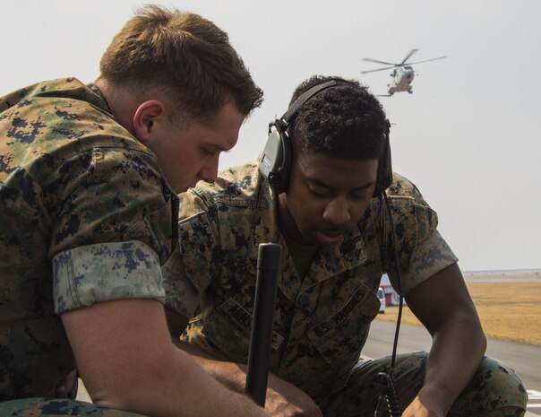U.S. Marine Corps Lance Cpls. Kevin McKee, left, and Byron Armstrong, right, communications technicians with Marine Air Control Squadron (MACS) 4, talk to Japan Maritime Self-Defense Force helicopter pilots during a cross-training exercise at Marine Corps Air Station Iwakuni, Japan, March 30, 2017. The Marines took part in a simulated forward arming and refueling points operation, where they communicated with JMSDF helicopter pilots to perform austere landings on a heliport that acted as an expeditionary runway. (U.S. Marine Corps photo by Lance Cpl. Carlos Jimenez)