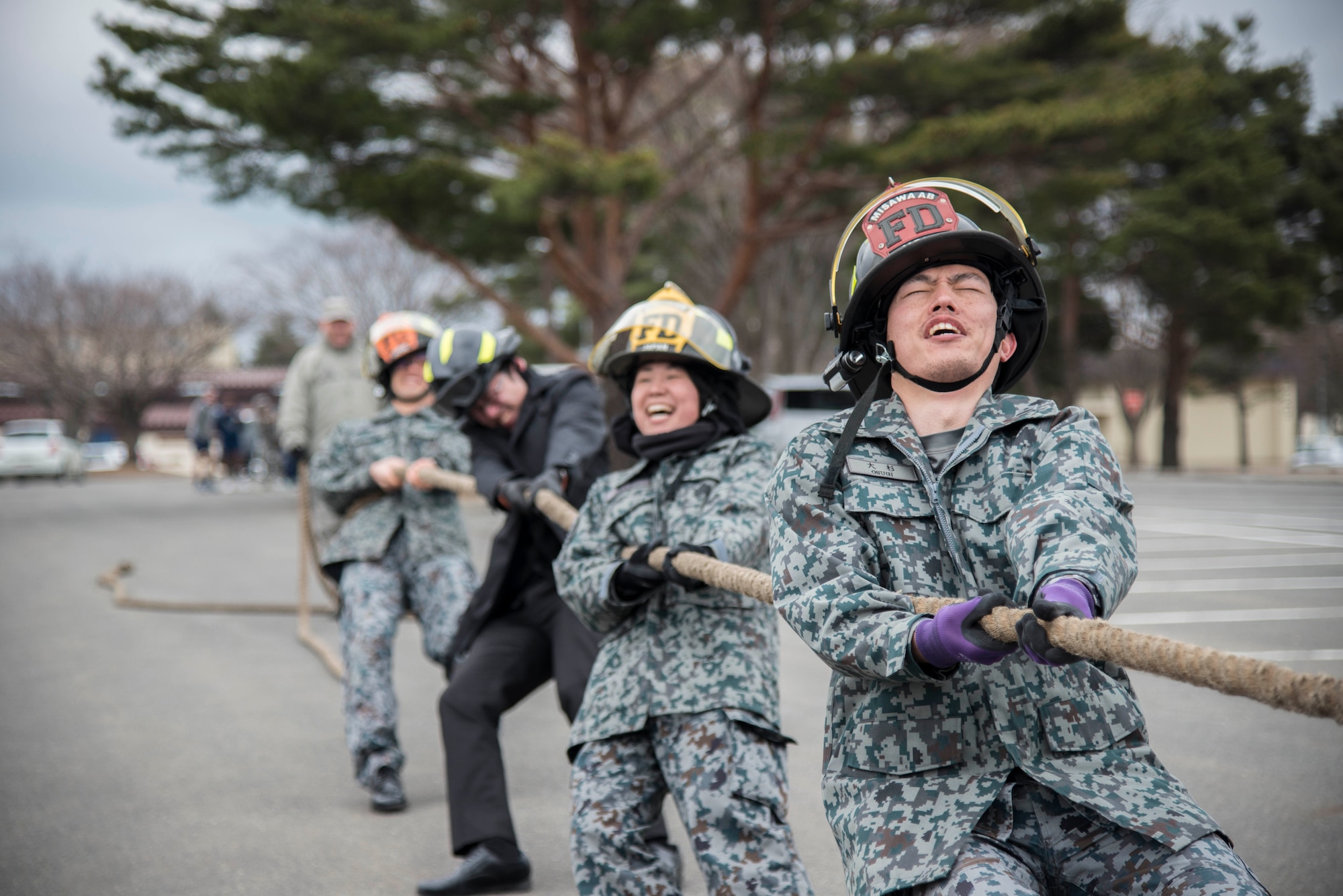 A team of Japanese Air Self-Defense Force members pull a firetruck during Wingman Day at Misawa Air Base, Japan, March 31, 2017. More than 10 teams entered the firetruck pull but team blank prevailed winning a grill. (U.S. Air Force Senior Airman Brittany A. Chase)
