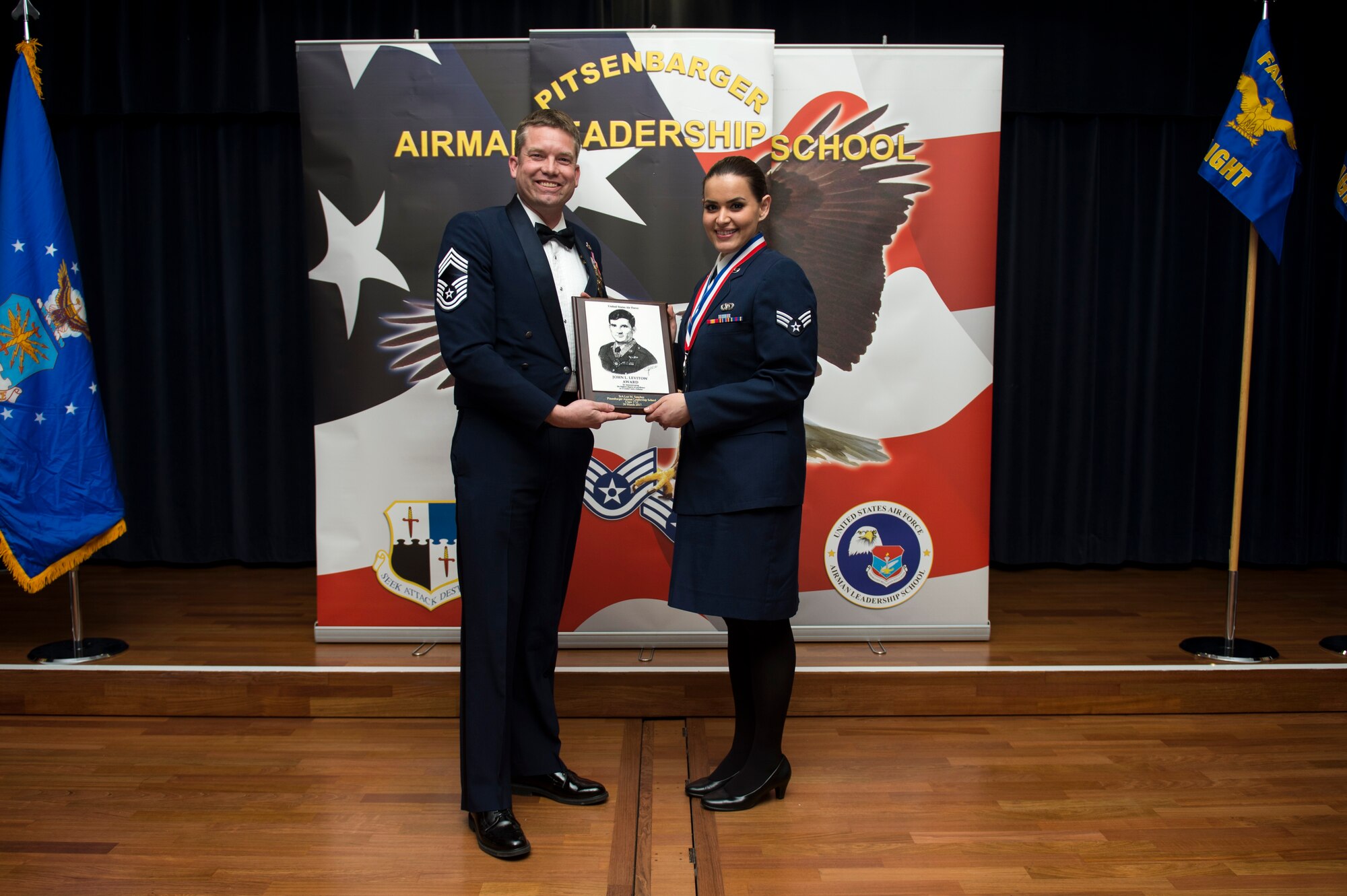 U.S. Air Force Senior Airman Luz Sanchez, right, 702nd Munitions Support Squadron emergency action controller, receives the John L. Levitow during the Pitsenbarger Airman Leadership School 17-C graduation at Club Eifel on Spangdahlem Air Base, Germany, Mar. 30, 2017. The Levitow award is the highest honor given to the student who displays excellence in all categories of ALS. (U.S. Air Force photo by Airman 1st Class Preston Cherry)