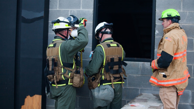 Marines with Chemical Biological Incident Response Force look for a point of entry into a collapsed building at Guardian Centers in Perry, Georgia, March 23, 2017 during Exercise Scarlet Response 2017.  The Marines conducted a search and rescue during a 36-hour field operation in order to extract victims in a simulated disaster. The field operation is the final event of the exercise.