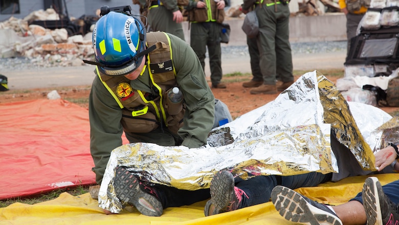 Hospitalman Russel Sanchez, a Corpsman with Chemical Biological Incident Response Force, provides care to a victim at Guardian Centers in Perry, Georgia, March 23, 2017, during Exercise Scarlet Response 2017.  The Marines conducted a search and rescue during a 36-hour field operation in order to extract victims in a simulated disaster. The field operation is the final event of the exercise.