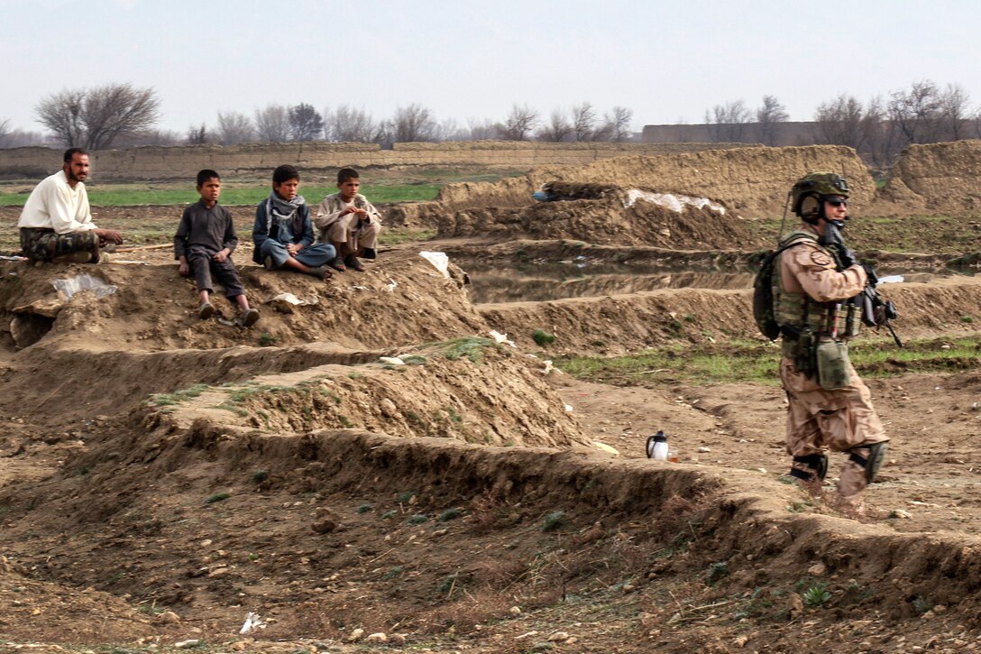 Local Afghan villagers watch as a Czech soldier provides security for U.S. Marines and Afghan soldiers patrolling near Bagram Airfield, Afghanistan, March 24, 2017. Army photo by Sgt. 1st Class LaSonya J. Johnson        