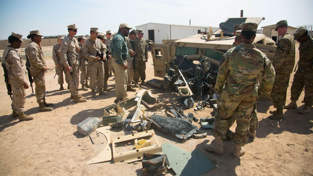 Marines with Combat Logistics Battalion 11, 11th Marine Expeditionary Unit (MEU), and soldiers with 3rd Armored Brigade Combat Team, 215th Brigade Support Bn., assess damage sustained on a tactical vehicle from an improvised explosive device during counter IED training as part of a sustainment training exercise at Camp Beuhring, Kuwait, Mar. 1. Counter IED measures are organized to aid in identifying and properly disposing of IEDs. SUSTEX provided the MEU additional training repetitions to reinforce combat skills as they make their way through the U.S. 5th Fleet area of responsibility.
