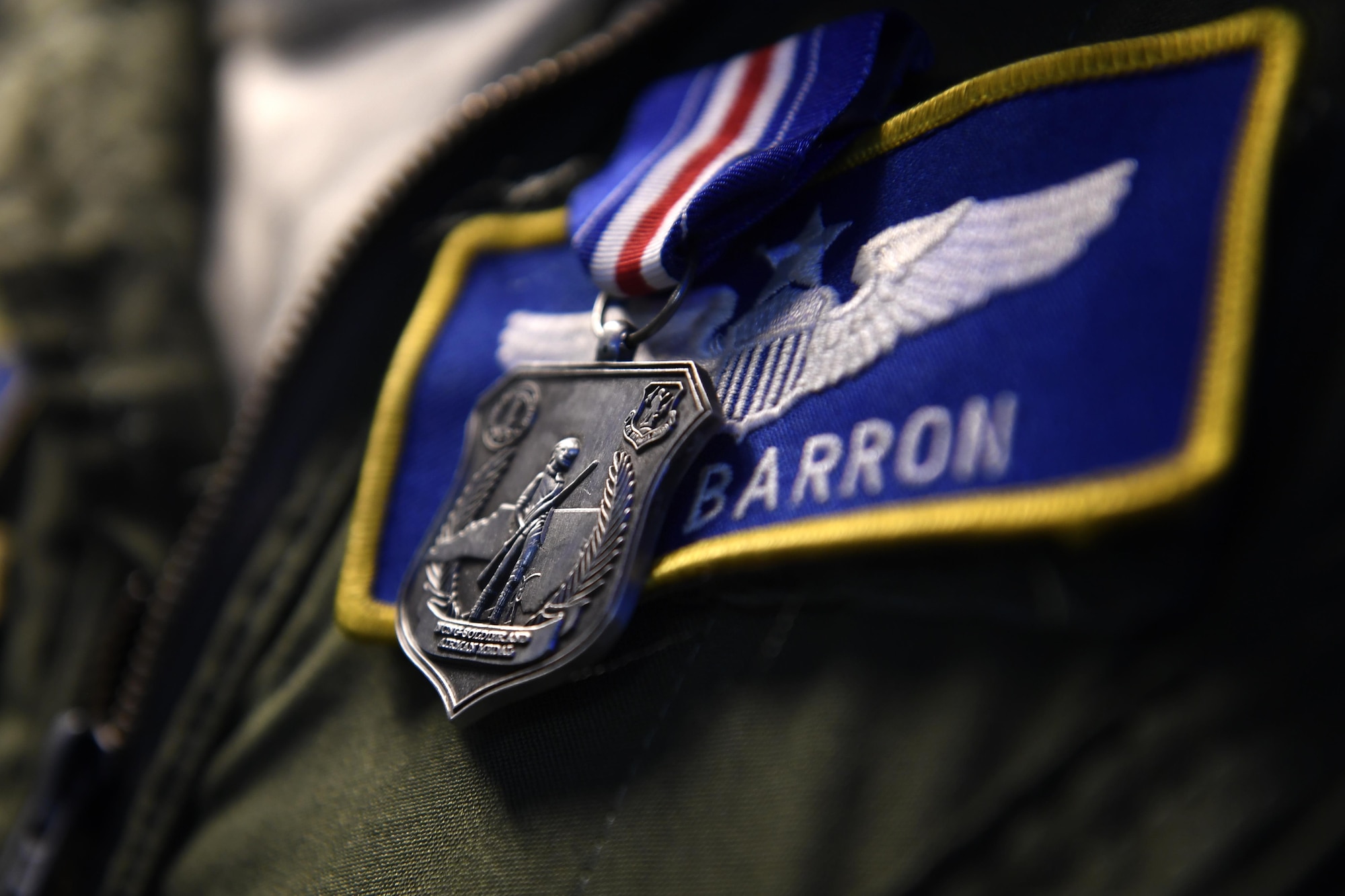 U.S. Air Force Maj. Nathan Barron, 156th Airlift Wing, shows his family the North Carolina National Guard Soldier and Airman Medal for heroism after a presentation ceremony held at the North Carolina Air National Guard Base, Charlotte Douglas International Airport, April 1, 2017. Barron was awarded the medal for his decisive and courageous actions as civilian pilot on a PSA Airlines flight where he tackling and maneuvering an unruly passenger to the ground after he assaulted a flight attendant. Barron continued to subdue the passenger until law enforcement arrived which saved the lives of the crew as well as others aboard the plane. The medal was recently created to honor Soldiers and Airmen for heroic actions performed while out of the military uniform.