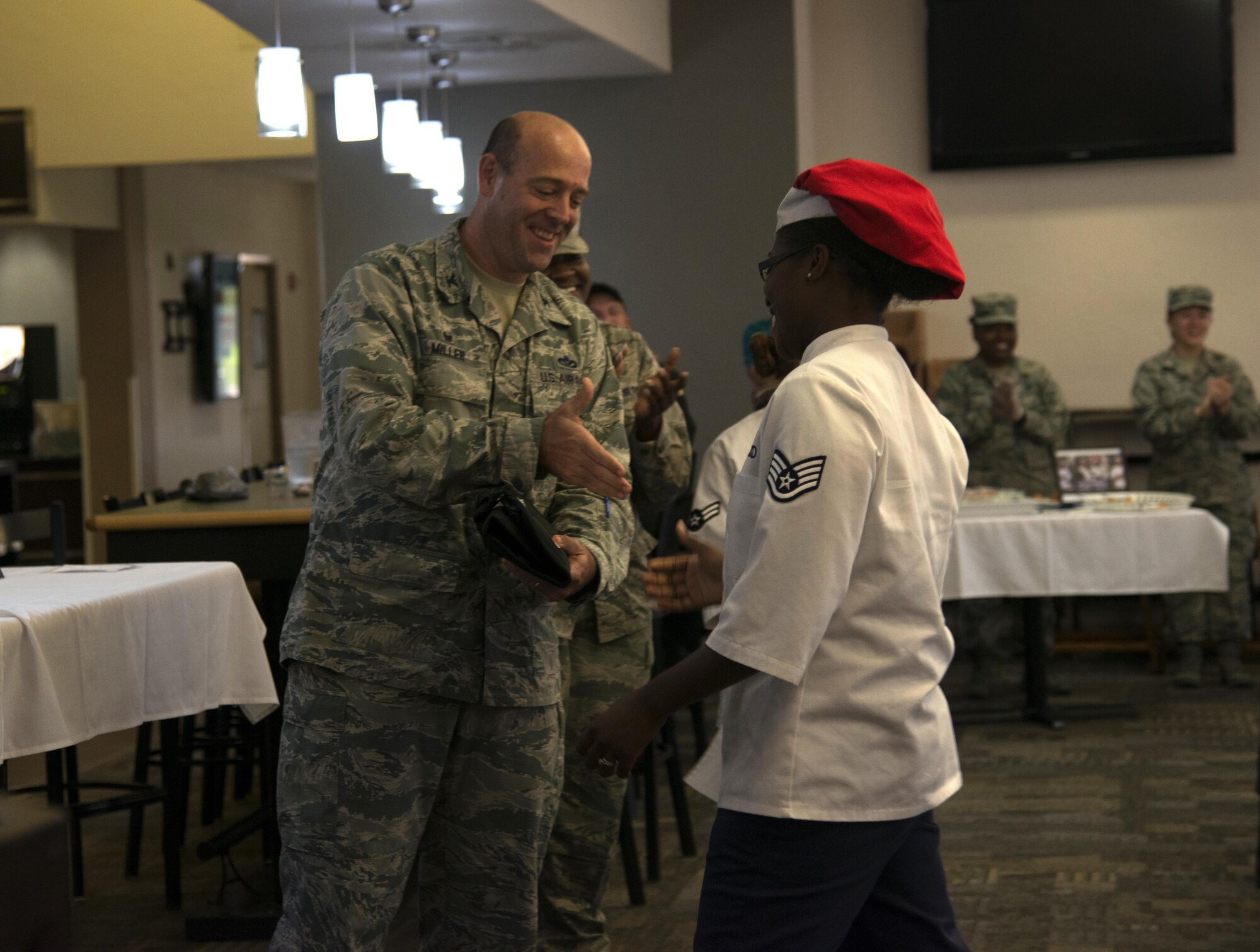 U.S. Air Force Col. Patrick Miller, commander of the 6th Mission Support Group, congratulates Staff Sgt. Vinsetta Buford, a food service specialist assigned to the 6th Force Support Squadron, on winning the first-ever MacDill Iron Chef Competition, March 28, 2017, at MacDill Air Force Base Fla. Buford received a custom engraved knife set. (U.S. Air Force photo by Airman 1st Class Rito Smith)