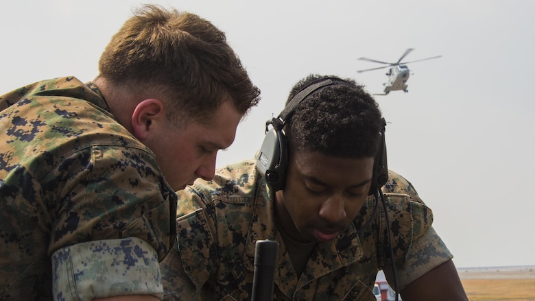 U.S. Marine Corps Lance Cpls. Kevin McKee, left, and Byron Armstrong, right, communications technicians with Marine Air Control Squadron 4, talk to Japan Maritime Self-Defense Force helicopter pilots during a cross-training exercise at Marine Corps Air Station Iwakuni, Japan, March 30, 2017. The Marines took part in a simulated forward arming and refueling points operation, where they communicated with JMSDF helicopter pilots to perform austere landings on a heliport that acted as an expeditionary runway.
