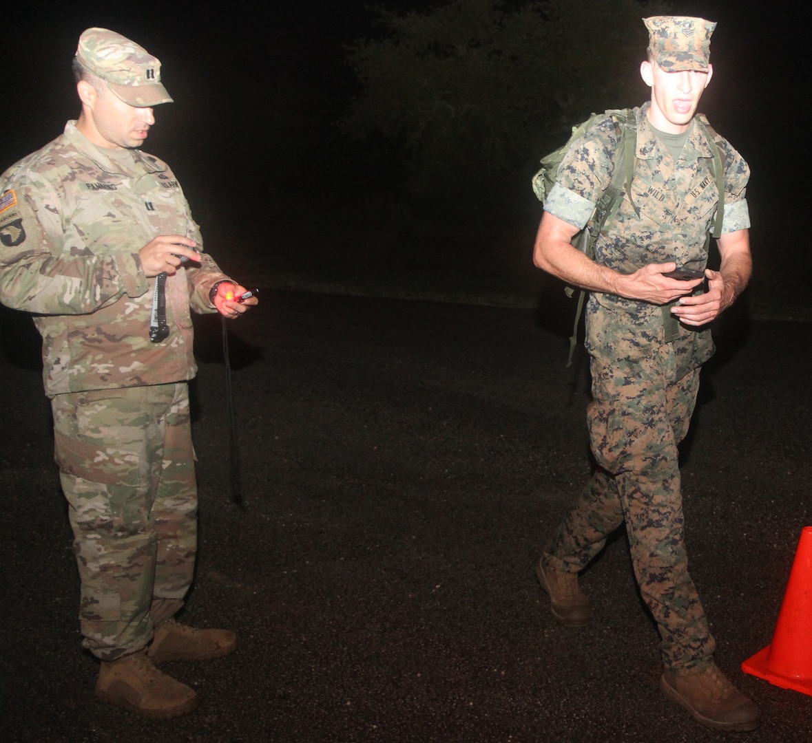 Seaman Adam Wild (right) shouts out his battle roster number at the half-way point of the 12-kilometer foot march on at Joint Base San Antonio-Camp Bullis April 2. Competitors carried a 33-pound rucksack during the final event of the three-day German Armed Forces Proficiency Badge testing. 