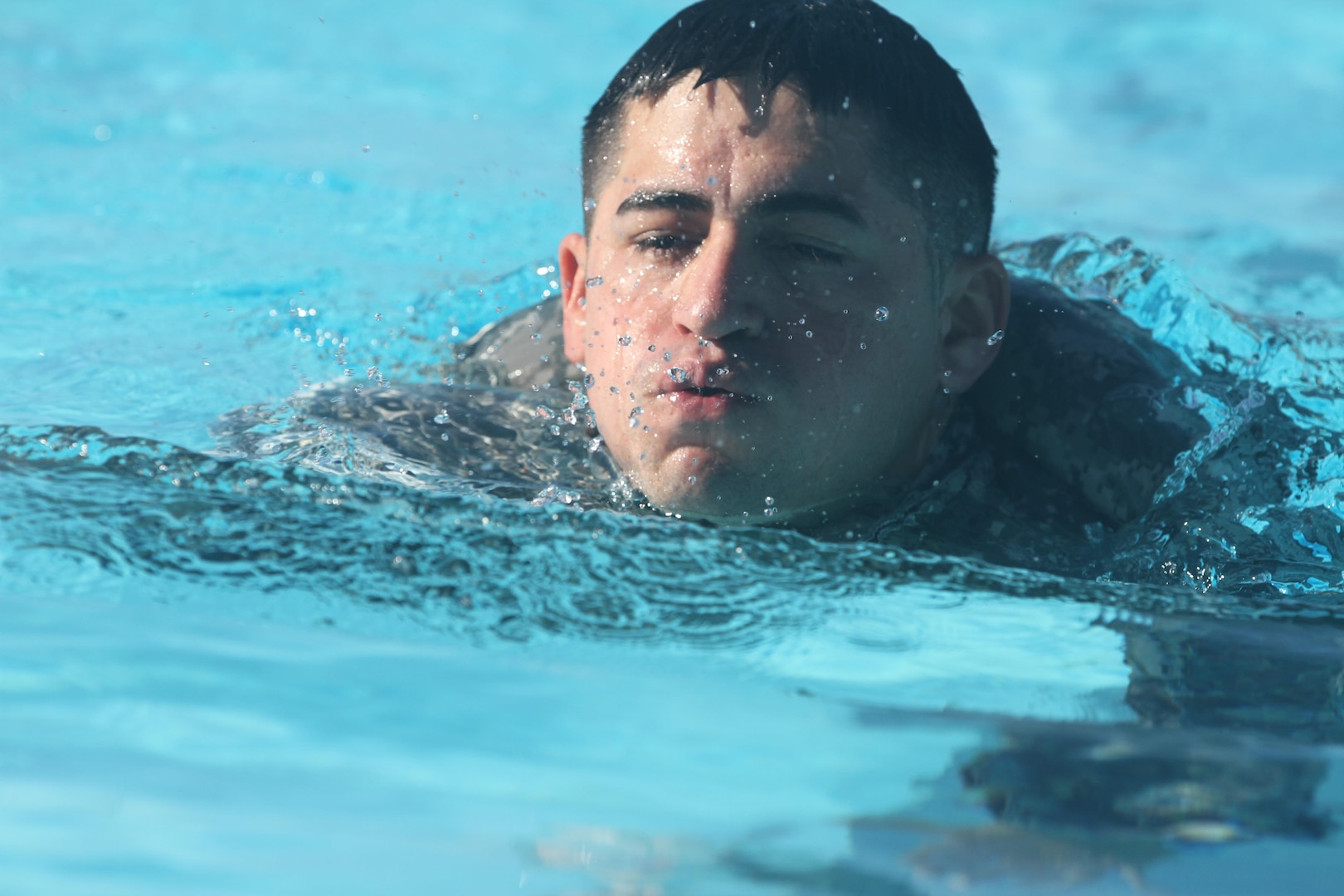 A U.S. service member treads water before removing his uniform as part of the German Armed Forces Proficiency Badge test at the Fort Sam Houston Aquatics Center at Joint Base San Antonio-Fort Sam Houston March 31. 