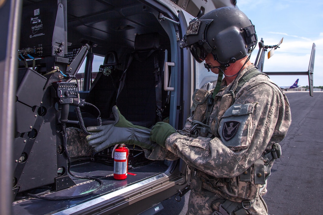 Georgia Army National Guard Sgt. Shawn Long prepares his gear before takeoff in a UH-72 Lakota helicopter during aerial firefighting exercise Operation Vigilant Guard in Ellabell, Ga., March 29, 2017. Long is a crew chef assigned to Detachment 1 Charlie Company, 2nd Battalion, 151st Service and Support. Army photo by Spc. Jesse Coggins