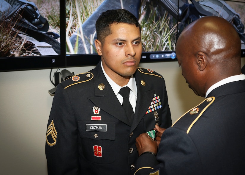 Command Sgt. Major Ronnie Farmer, command sergeant major for the 335th Signal Command (Theater), presents the Army Commendation Medal to Army Reserve Staff Sgt. Erick Guzman, information technology staff noncommissioned officer, assigned to the 820th Signal Company, 98th Expeditionary Signal Battalion, 335th SC (T), during an awards ceremony at the command’s 2017 Best Warrior Competition at Fort Huachuca, Arizona March 31.  After five-days of demanding physical and mental challenges Guzman was named the command’s Best Warrior for the noncommissioned officer ranks, and will go on to represent the command at the U.S. Army Reserve Command’s Best Warrior Competition later this year.  (Official U.S. Army Reserve photo by Sgt. 1st Class Brent C. Powell)
