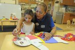 Sylvia Munoz, Child Development Center pre-school teacher, assists Brooke Correa on decorating a Cardboard Kid cut-out for Child Abuse Prevention and Awareness Month March 30, 2017, at Joint Base San Antonio-Randolph, Texas.  Cardboard Kid cut-outs, representing victims of child abuse will be displayed throughout JBSA during the month of April.  (U.S. Air Force photo by Joel Martinez)