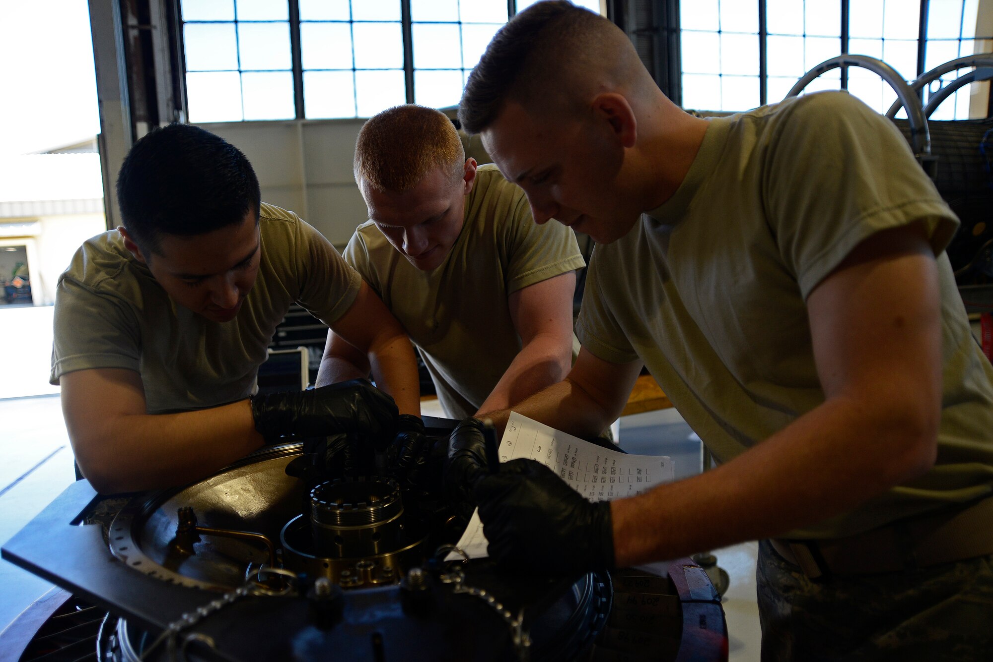 U.S. Air Force Airman 1st Class Jesus Ortega 20th Component Maintenance Squadron (CMS) aerospace propulsion journeyman, left, Airman 1st Class Caleb Gulley, center, and Airman 1st Class Andrew Setrin, right, 20th CMS aerospace propulsion apprentices, work together on the number two sump housing at Shaw Air Force Base, S.C., March 29, 2017. The number two sump housing works with the number three sump housing as the support fan and core compressor rotors for the F110-129D engine. (U.S. Air Force photo by Airman 1st Class BrieAnna Stillman)