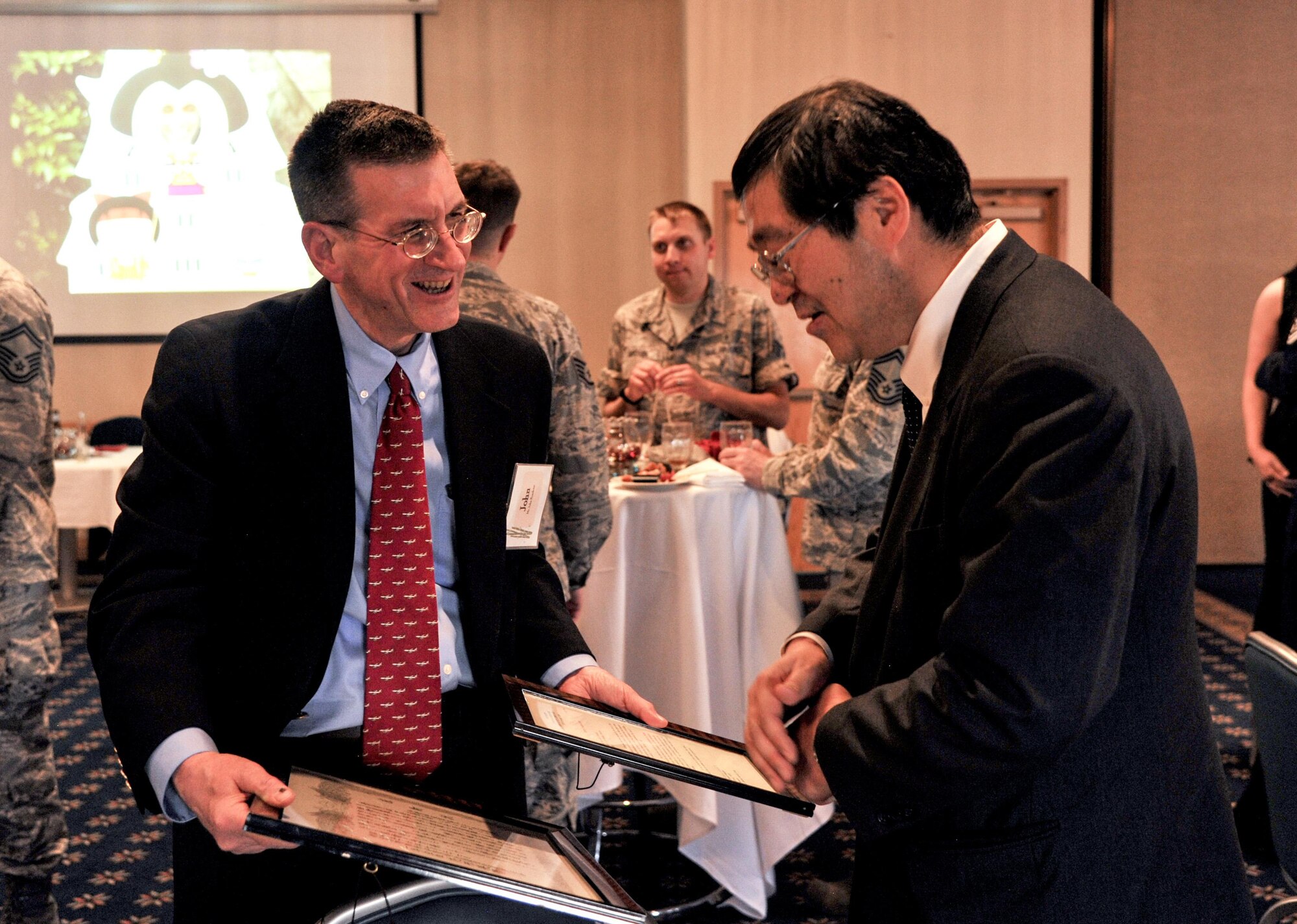 John Horadcap, Air Force Research Laboratories senior research meteorologist, shows Consul-General of Japan Hiroto Hirakoba two letters of appreciation he received during his time in Japan during a lunch reception at the Mountain View Club on Kirtland Air Force Base, Mar. 31. Horadcap spent two years in Kadena from 1979 to 1981 and spoke on his experiences there during the event. 